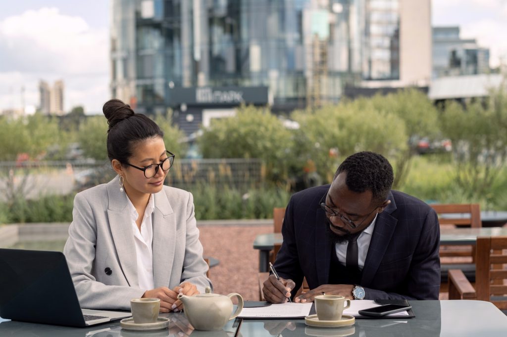 African businessman signing contract with Asian business partner